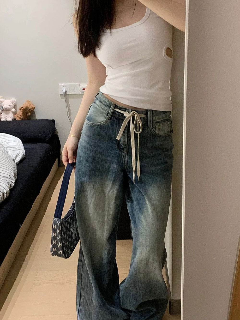 Calça jeans baggy de modelagem ampla com lavagem vintage estonada e cordão longo ajustável na cintura