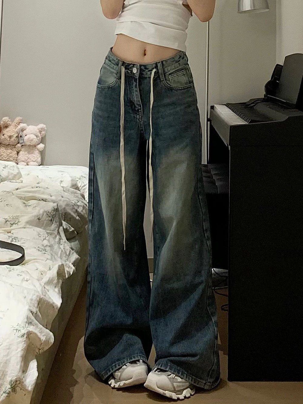 Calça jeans baggy de modelagem ampla com lavagem vintage estonada e cordão longo ajustável na cintura