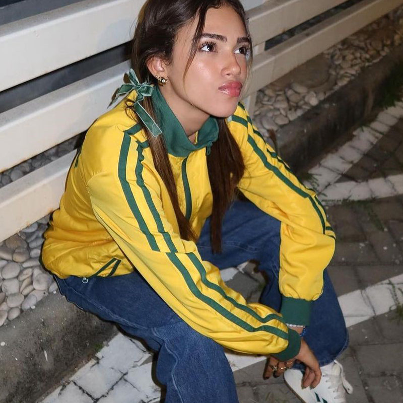 Jaqueta nas cores verde e amarela com fechamento frontal em zíper e gola alta
