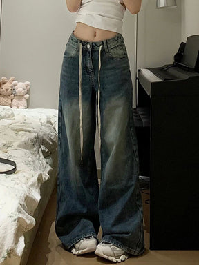 Calça jeans baggy de modelagem ampla com lavagem vintage estonada e cordão longo ajustável na cintura