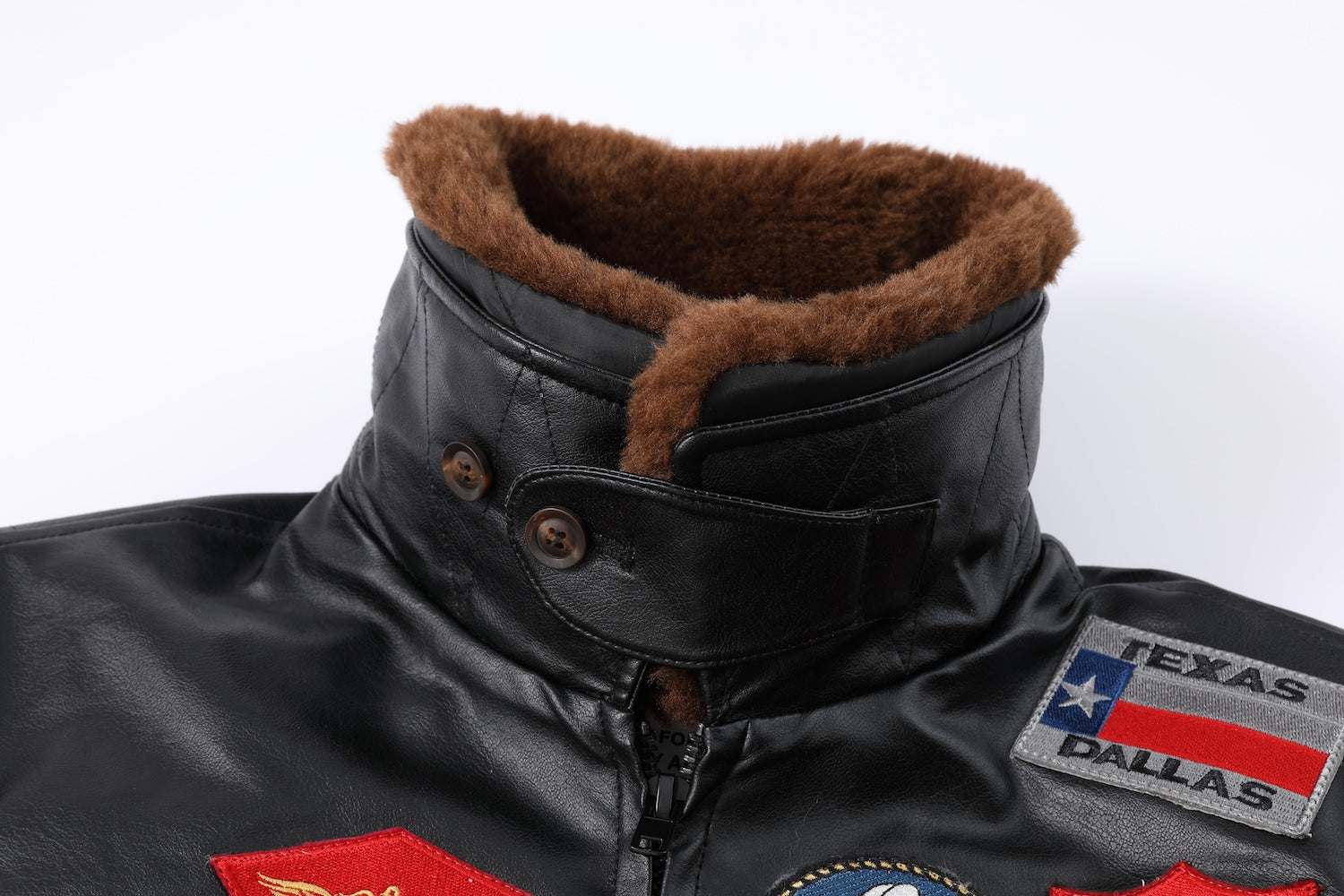 Jaqueta bomber preta com gola de pelo marrom e diversos patches militares no peito, costas e mangas