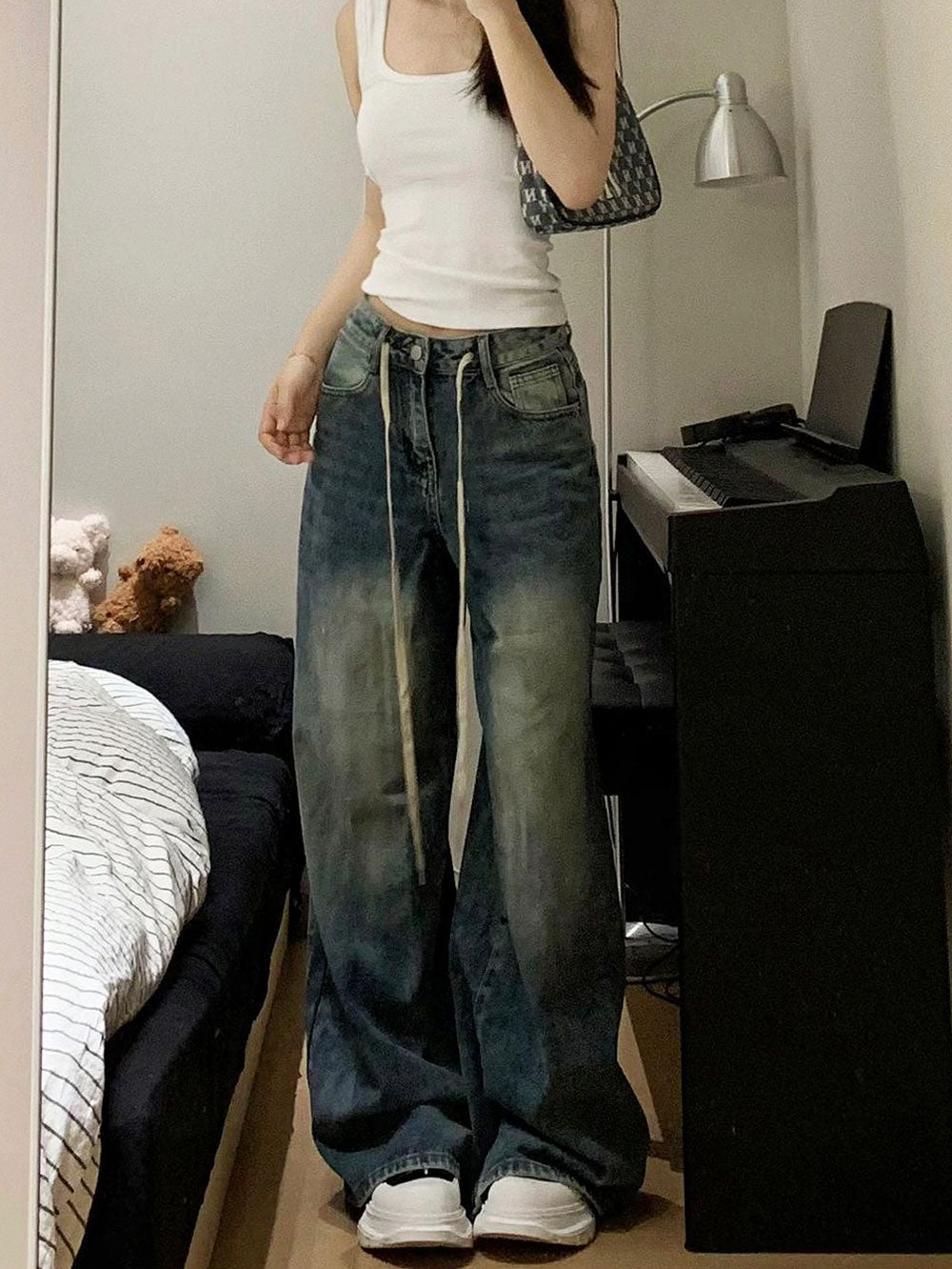 Calça jeans baggy de modelagem ampla com lavagem vintage estonada e cordão longo ajustável na cintura