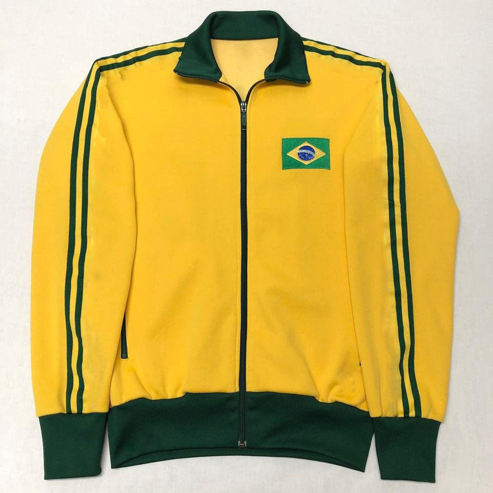 Jaqueta nas cores verde e amarela com fechamento frontal em zíper e gola alta