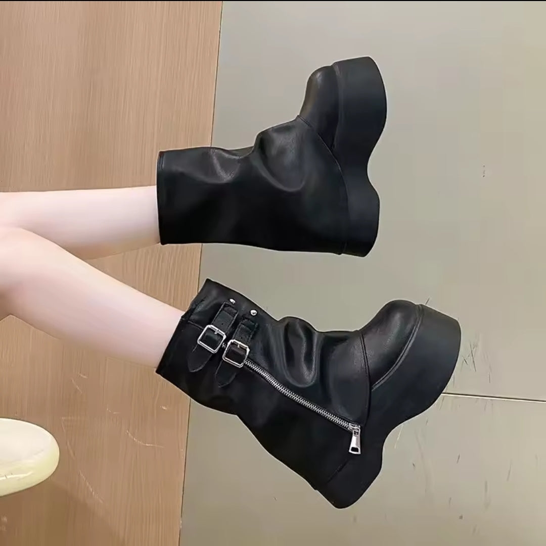 Bota biker preta de cano curto com plataforma tratorada, zíper lateral e fivelas duplas